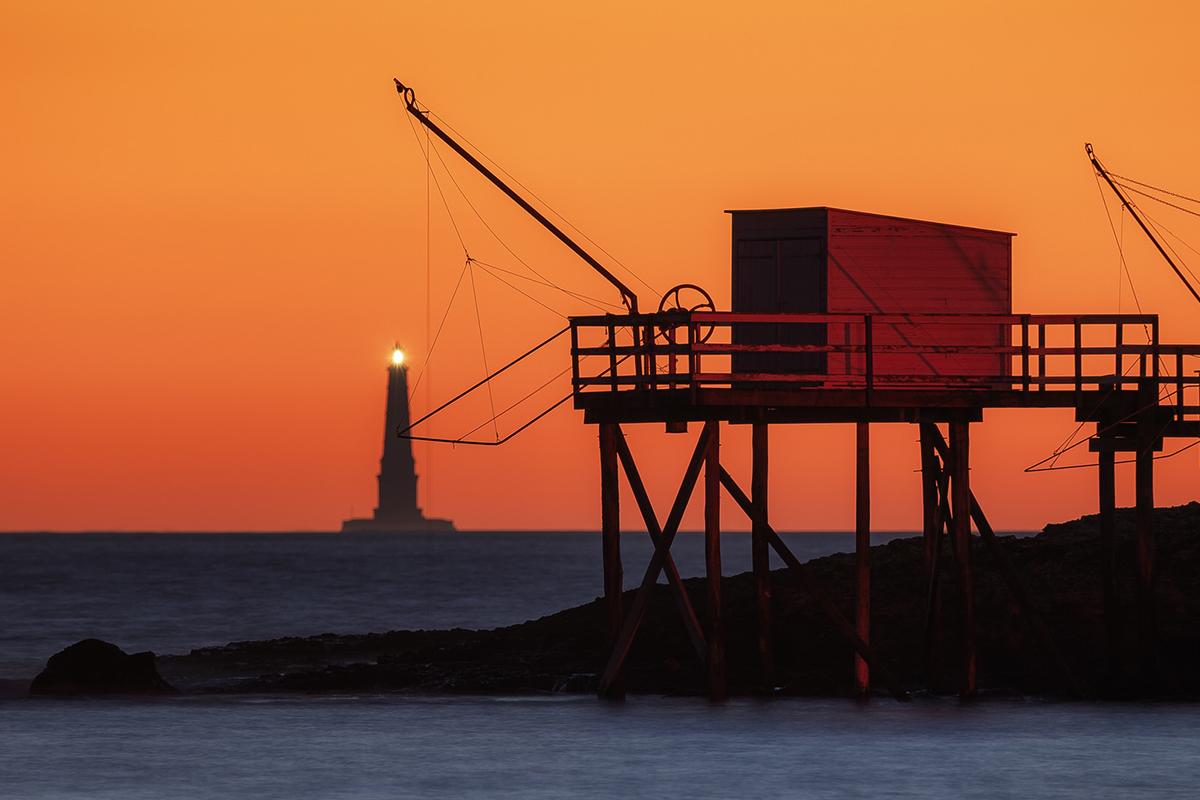 photo phare de cordouan et carrelets au coucher de soleil